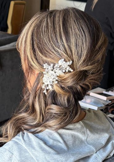 Elegant hairstyle with a pearl and crystal hair accessory.