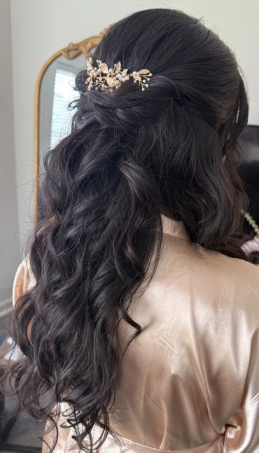 Elegant half-up hairstyle with decorative hair accessory.