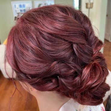 Elegant braided updo with rich burgundy hair color.