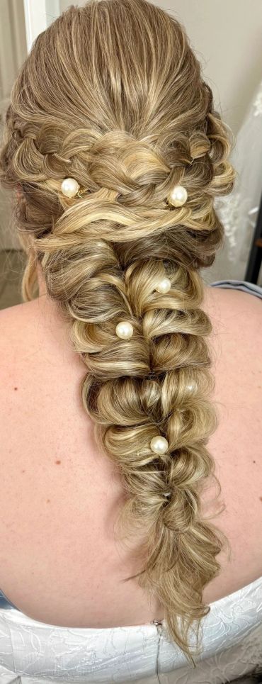 Elegant braided hairstyle with pearl accessories.