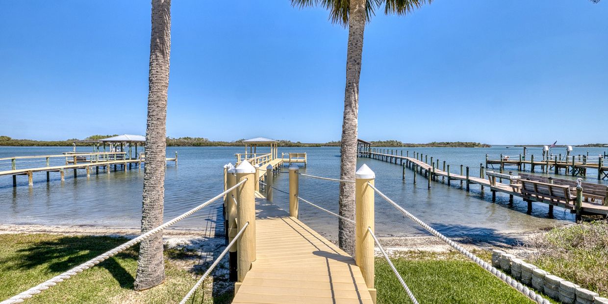 Wooden pier extending into calm blue waters under clear skies.