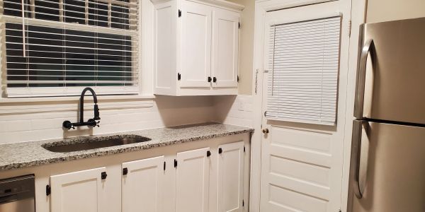 Clean modern kitchen corner with white cabinets.