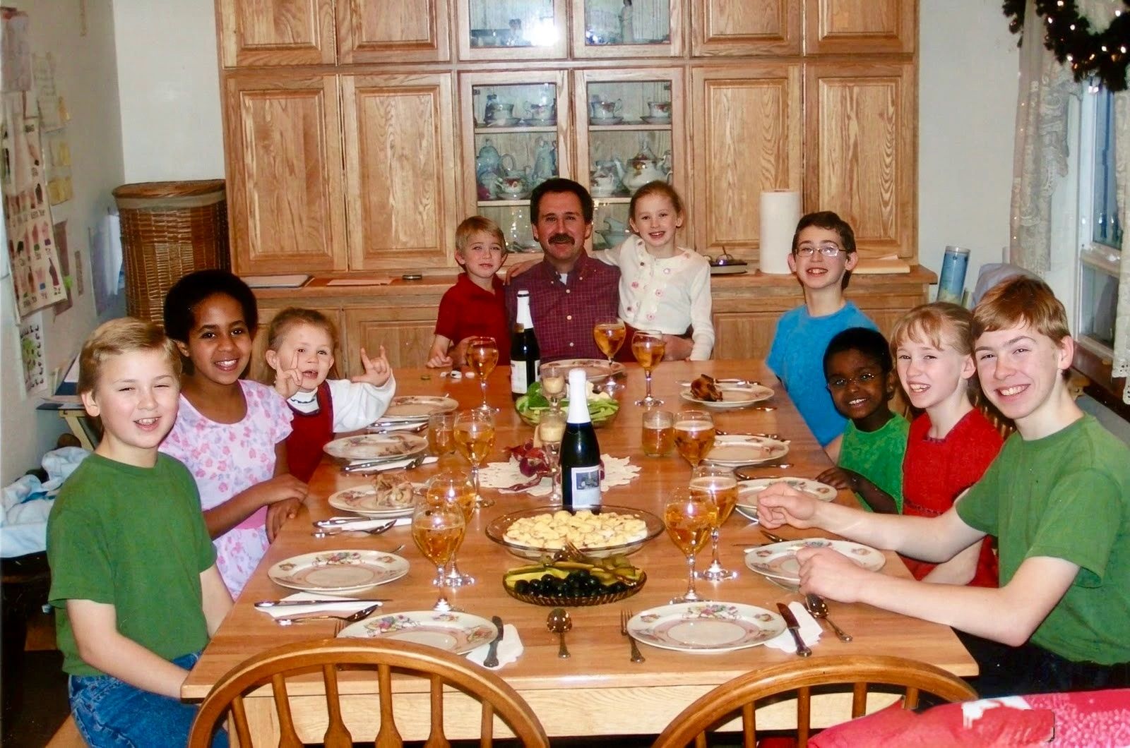 Family and friends gather around a table for a meal.