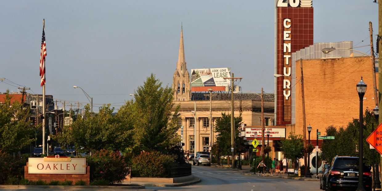 Downtown Oakley street with Century theater and church steeple at sunset.