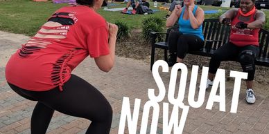Three women exercising outdoors with a focus on squats.