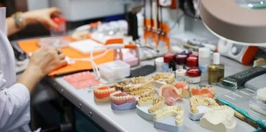 Dental technician working on dental molds and prosthetics.