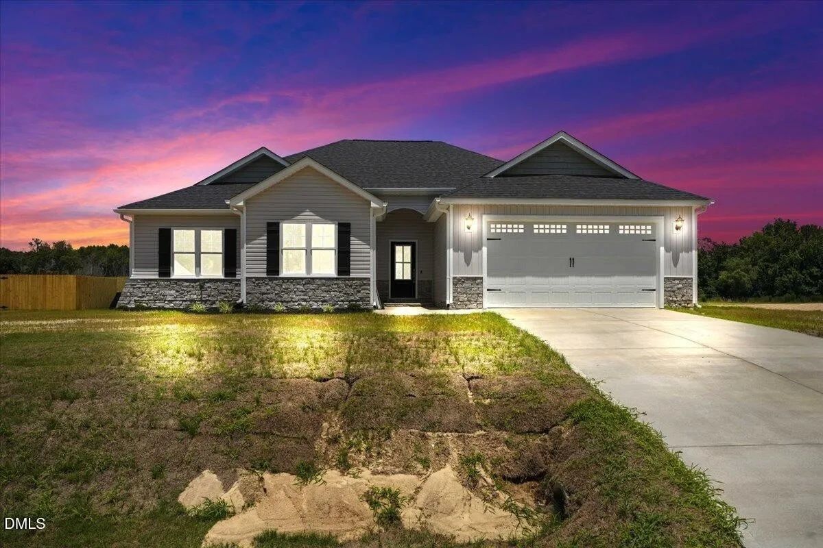 Modern house lit up at twilight with a vibrant sunset.