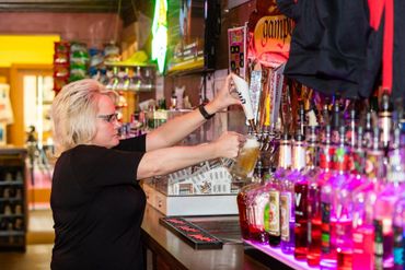 A woman filling the glass with drink on display