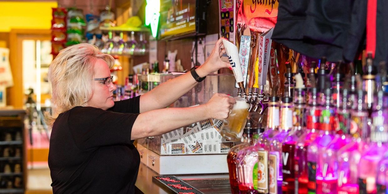 A woman filling the drink in the glass on display