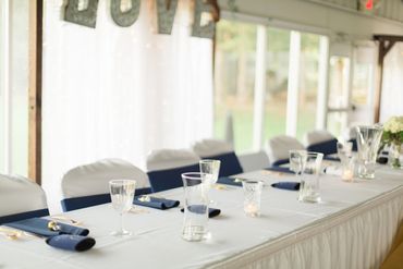 Decorated head table inside of wedding reception.