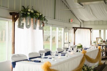 Decorated wedding ceremony head table inside of the venue.