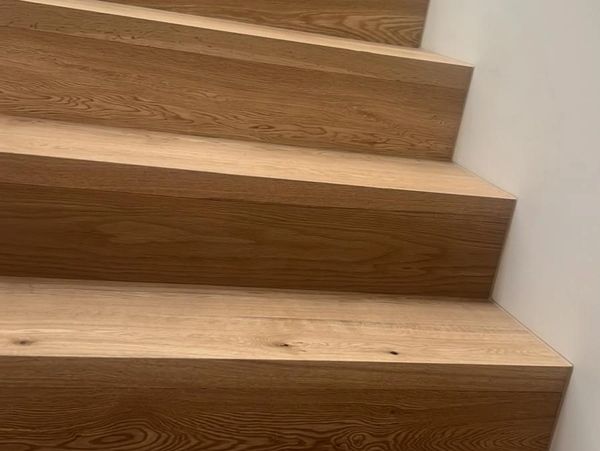 Modern wooden staircase with clean lines and light wood finish.