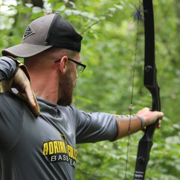 Bow shooting picture of a man practicing inside a jungle