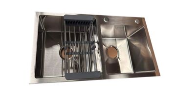 Double-basin stainless steel kitchen sink with a drying rack in one basin.