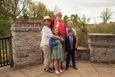 Group photo with a man in festive attire and children.