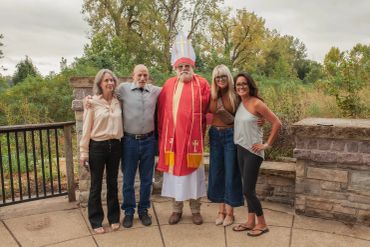 Group photo of five people, including a bishop in red robes.