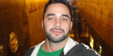 Man taking a selfie in a warmly lit indoor setting.