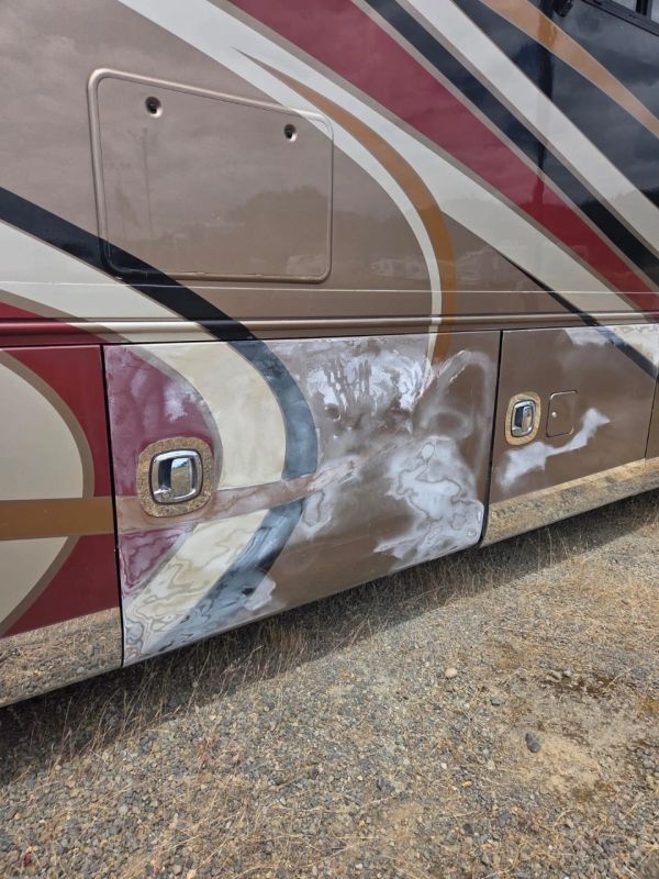 Partially sanded side panel of a painted vehicle.