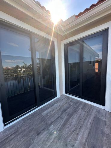 Sunlit balcony with sliding glass doors.