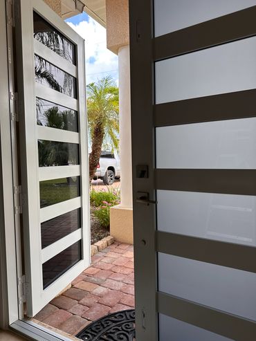 Modern front doors with glass panels partially open.