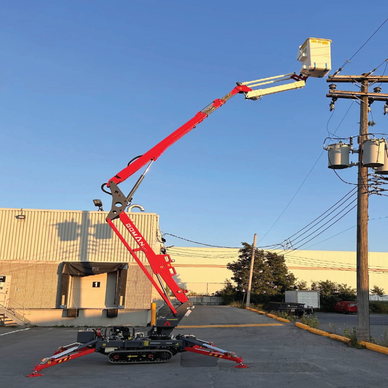 A red robotic arm lift platform working on power lines against a clear sky.
