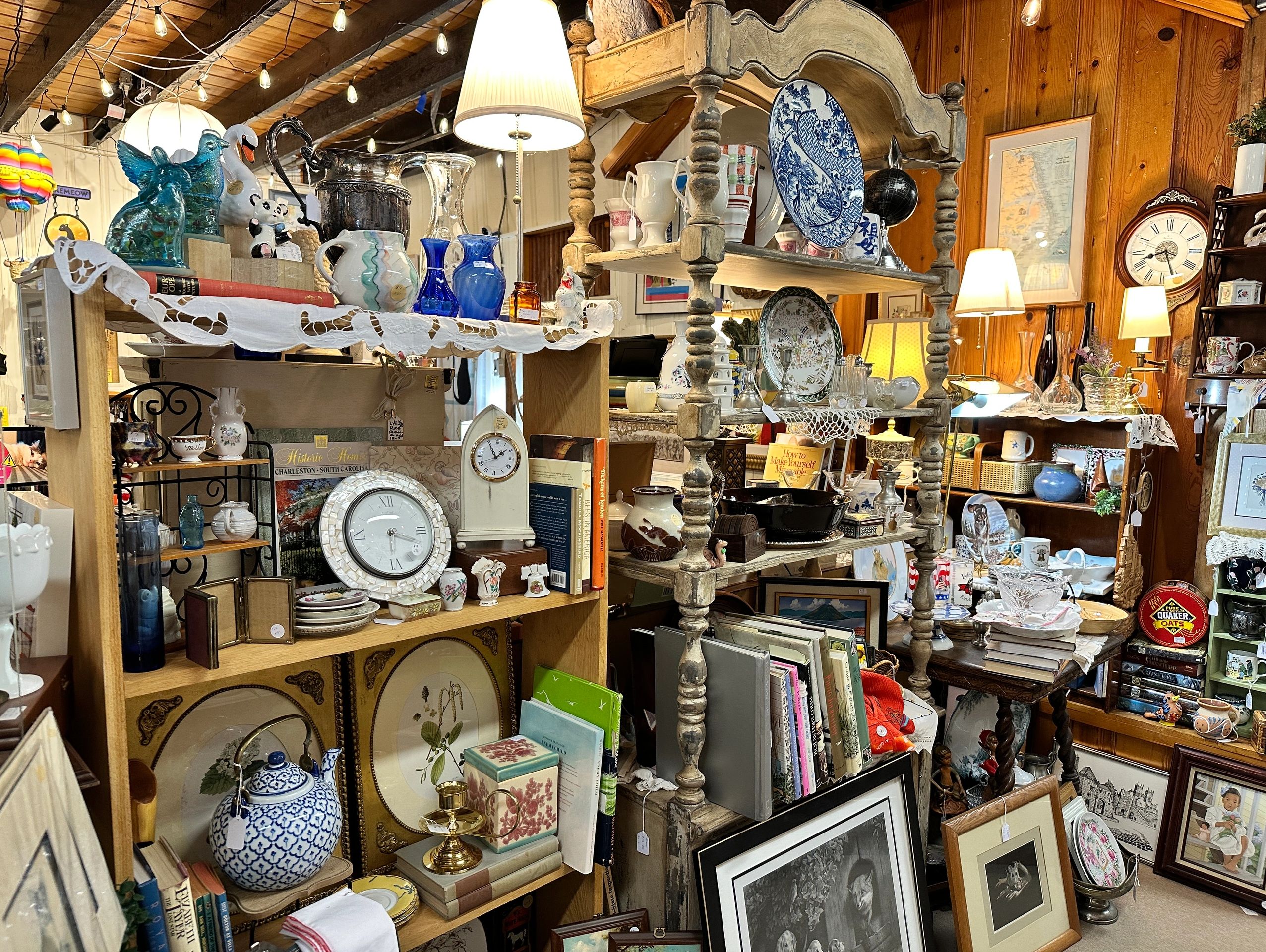 Antique shop with shelves of various vintage items and books.