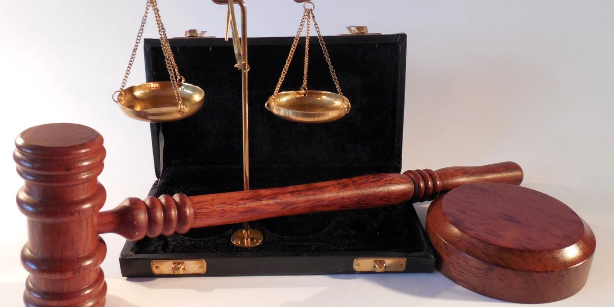 Wooden gavel and brass scales of justice.
