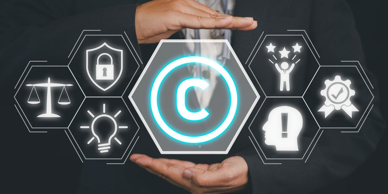 Hands protect glowing copyright symbol with related icons.