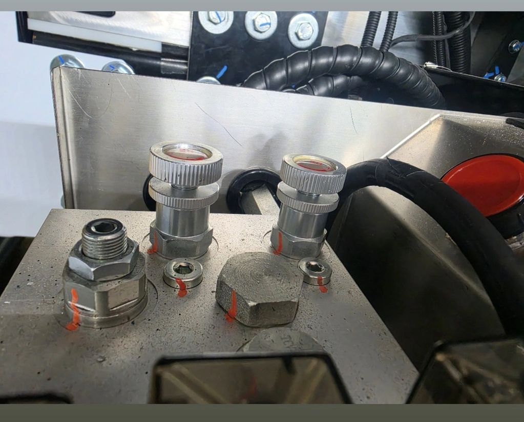 Hydraulic connections on an ambulance tail-lift system checked against schematics.