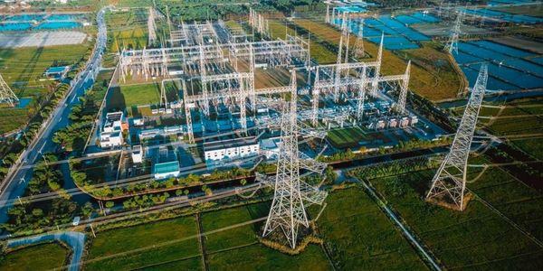Electrical substation amidst green fields.