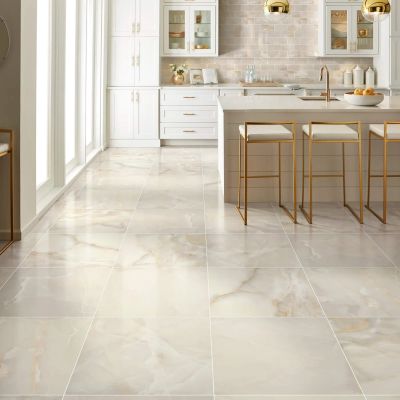 Elegant kitchen with glossy marble flooring and gold-accented bar stools.