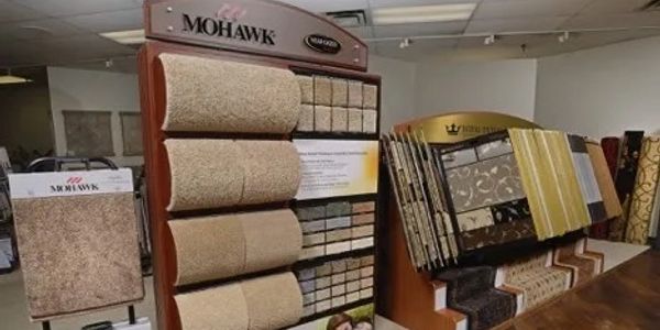 Display stands showing various carpet samples in a flooring store.