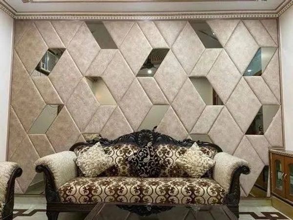 Elegant sofa with ornate patterns in front of a geometric padded wall with mirrors.