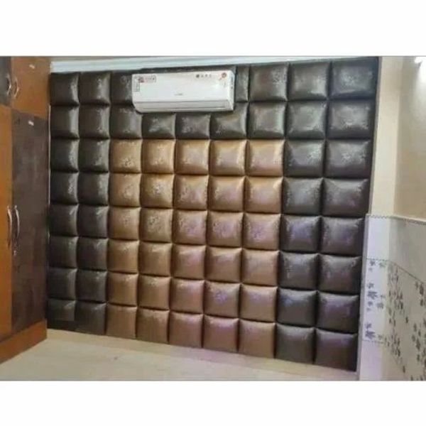 Padded wall design with brown and black leather squares under an air conditioner.