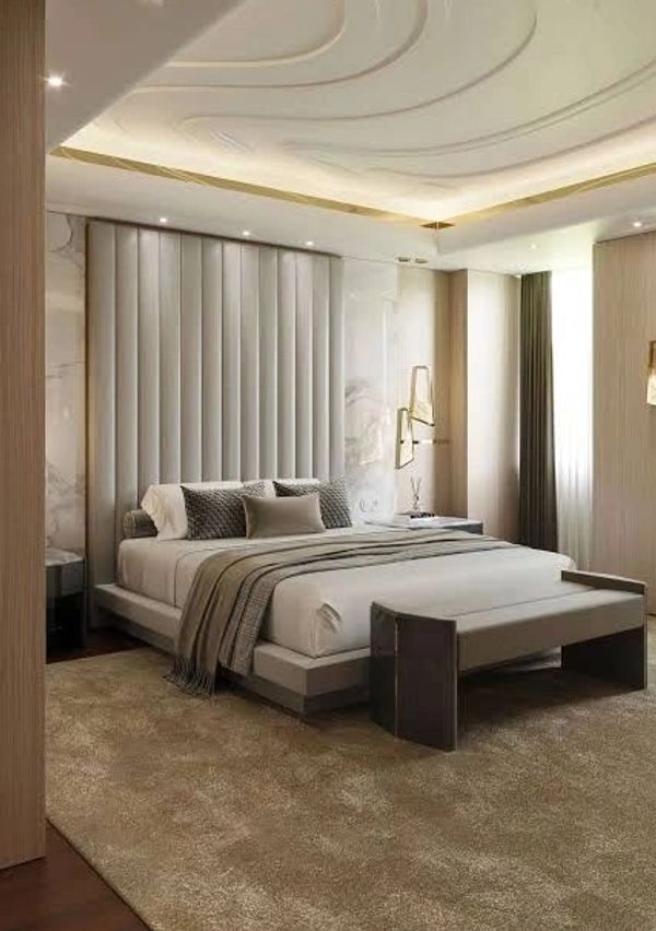 Elegant modern bedroom with a large bed, soft lighting, and neutral tones.