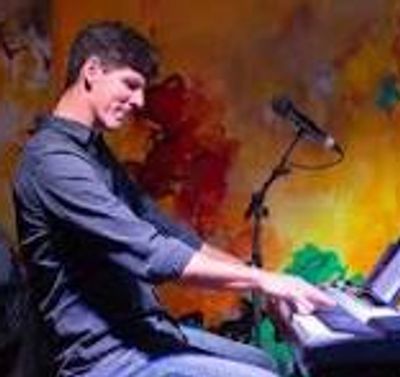 Man playing keyboard with a colorful background.