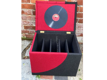 Red and black vinyl record storage box with dividers and record on lid.