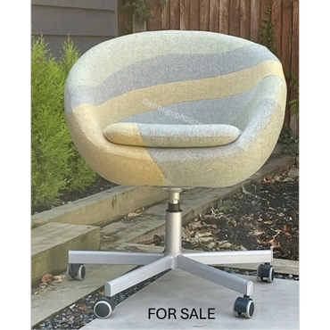 Modern swivel chair with pastel stripes on wheels, set outdoors.