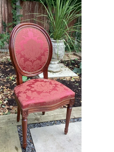 Elegant vintage chair with red patterned upholstery and wooden frame.