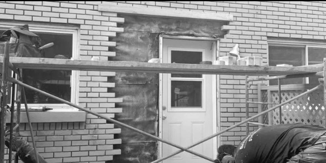 Découpe de mur de brique et installation de linteau pour agrandissement de fenêtre