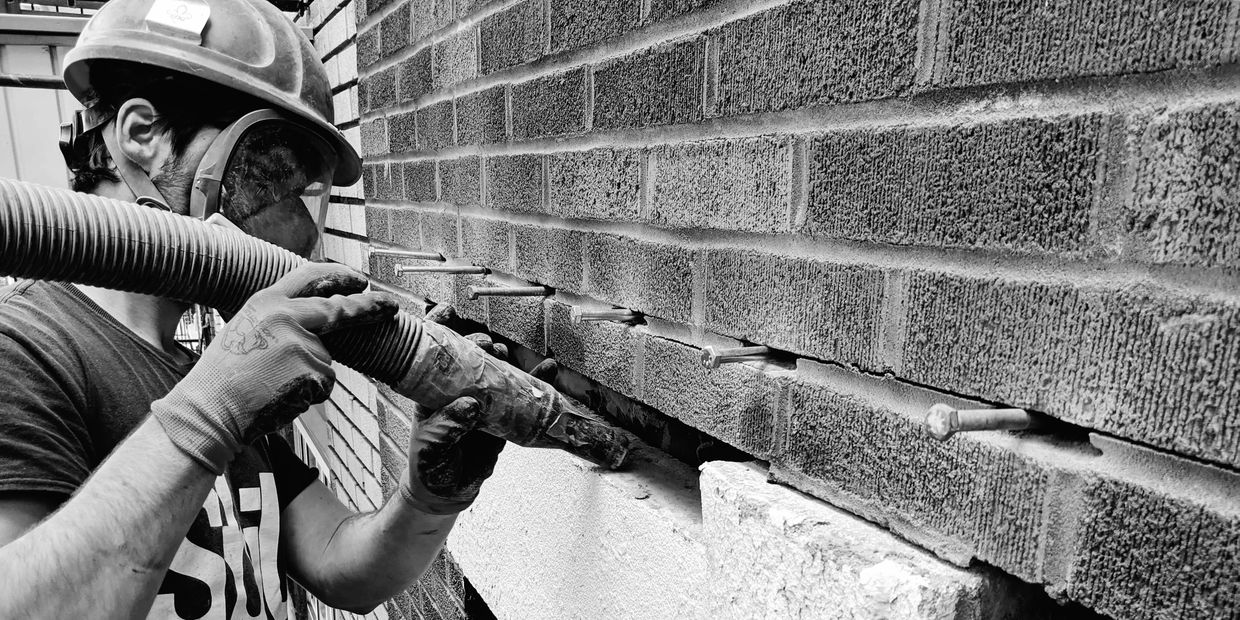 Remplacement d'un linteau de pierre fissuré sur une façade en brique