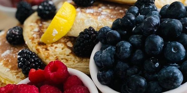 American fluffy pancakes, crispy streaky bacon, blueberries, raspberries, maple syrup, blackberries