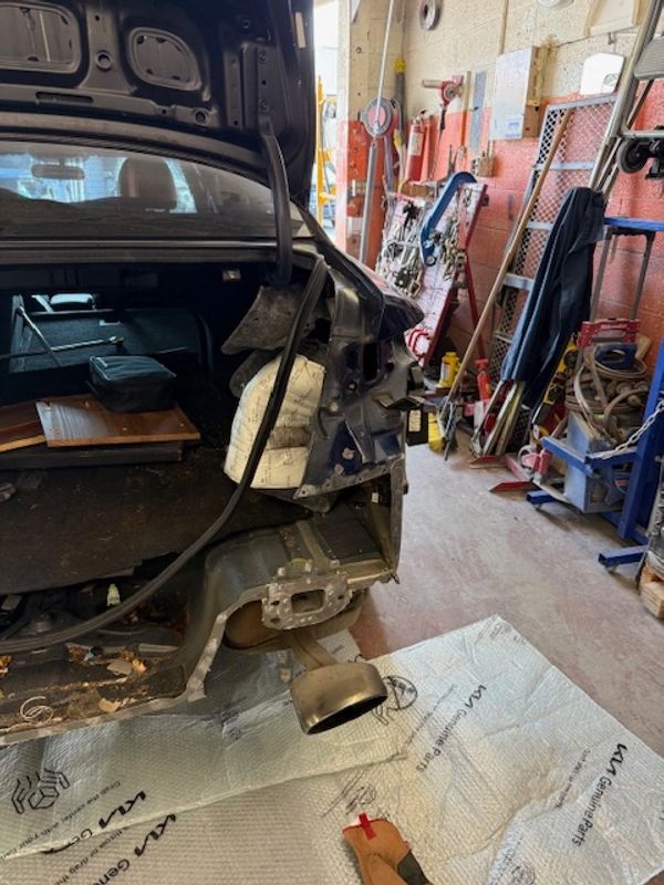 Car with rear section dismantled in a workshop.