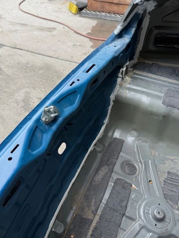 Interior view of a stripped car chassis showing blue painted metal and floor pan.