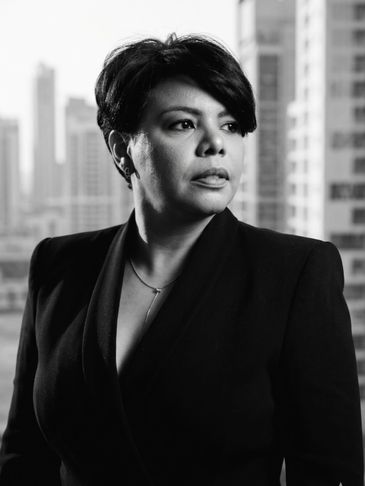 Black and white portrait of a confident woman in professional attire.