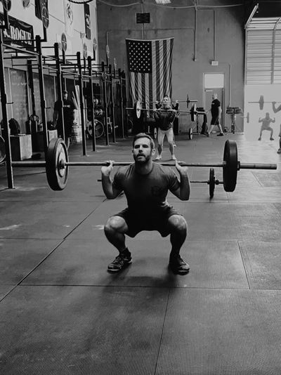 Group of people lifting weights in a CrossFit class. 