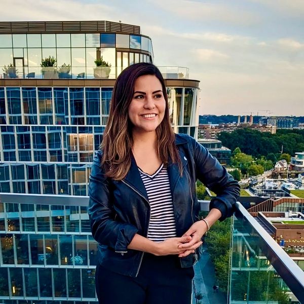 Fatima Terry standing on a rooftop patio at sunset looking ahead with optimism.