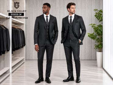 Two men wearing black formal suits in a stylish clothing store.