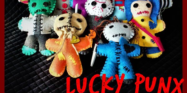 Colorful handmade voodoo dolls with stitched faces and outfits.