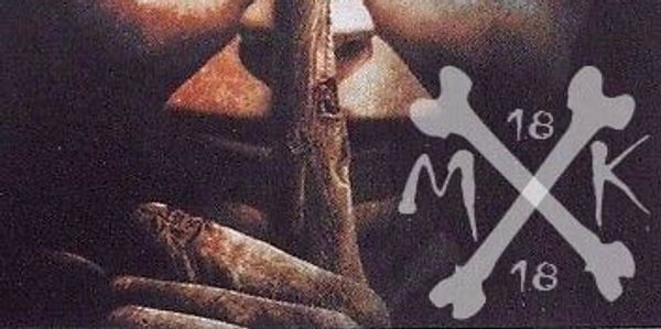 A person holding a stick with crossed bones and the numbers 18, letters M and K.